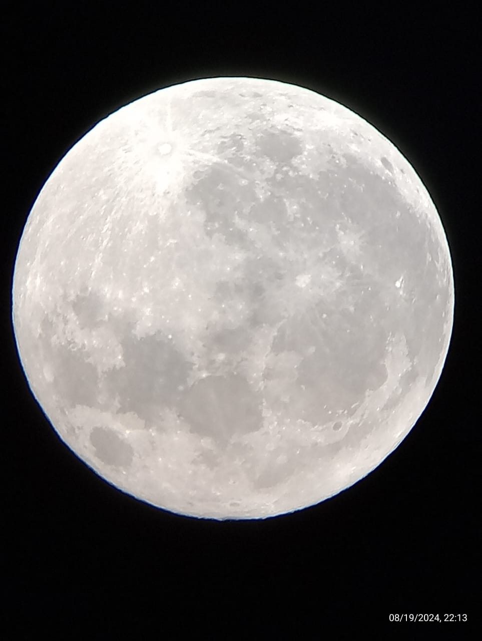  A imagem mostra uma lua cheia em um céu noturno escuro. A lua está posicionada no centro da imagem e ocupa a maior parte do quadro.