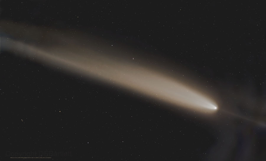 A imagem captura um cometa em um céu noturno estrelado. O cometa é o objeto central da imagem e se destaca por sua cauda luminosa que se estende por uma grande parte do quadro.