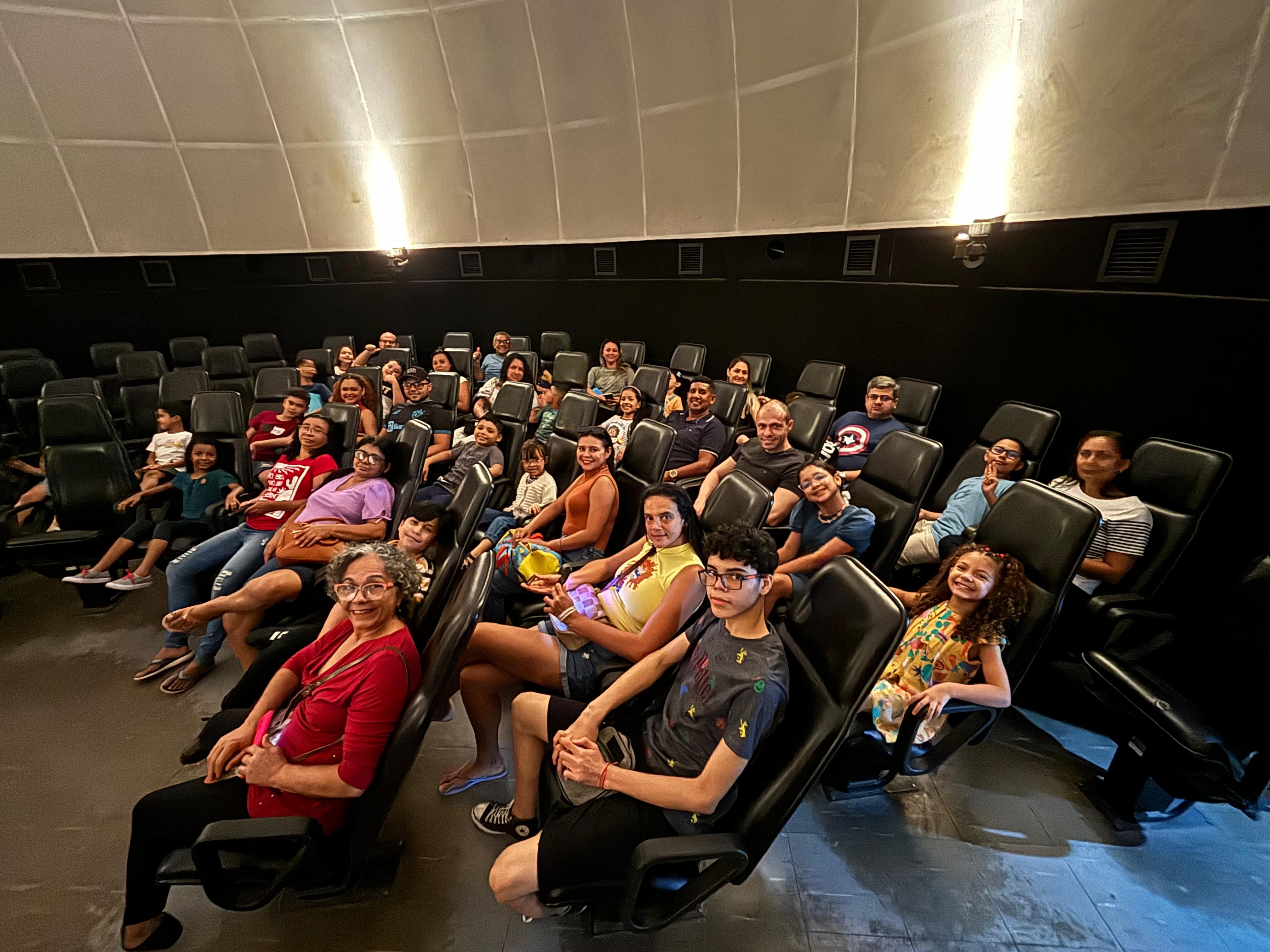 A imagem mostra um grupo de pessoas sentadas, durante a sessão de cúpula do Centro de Ciências e Planetário do Pará. 