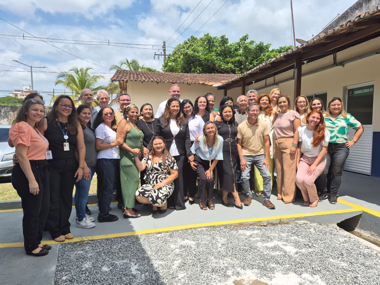 A imagem mostra um grupo de pessoas em pose para uma foto em frente a um prédio da instituição